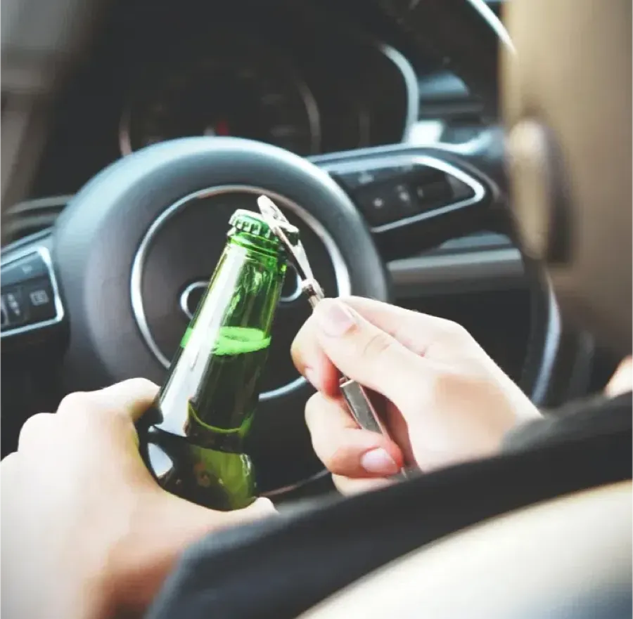 Driver opening a bottle behind the wheel